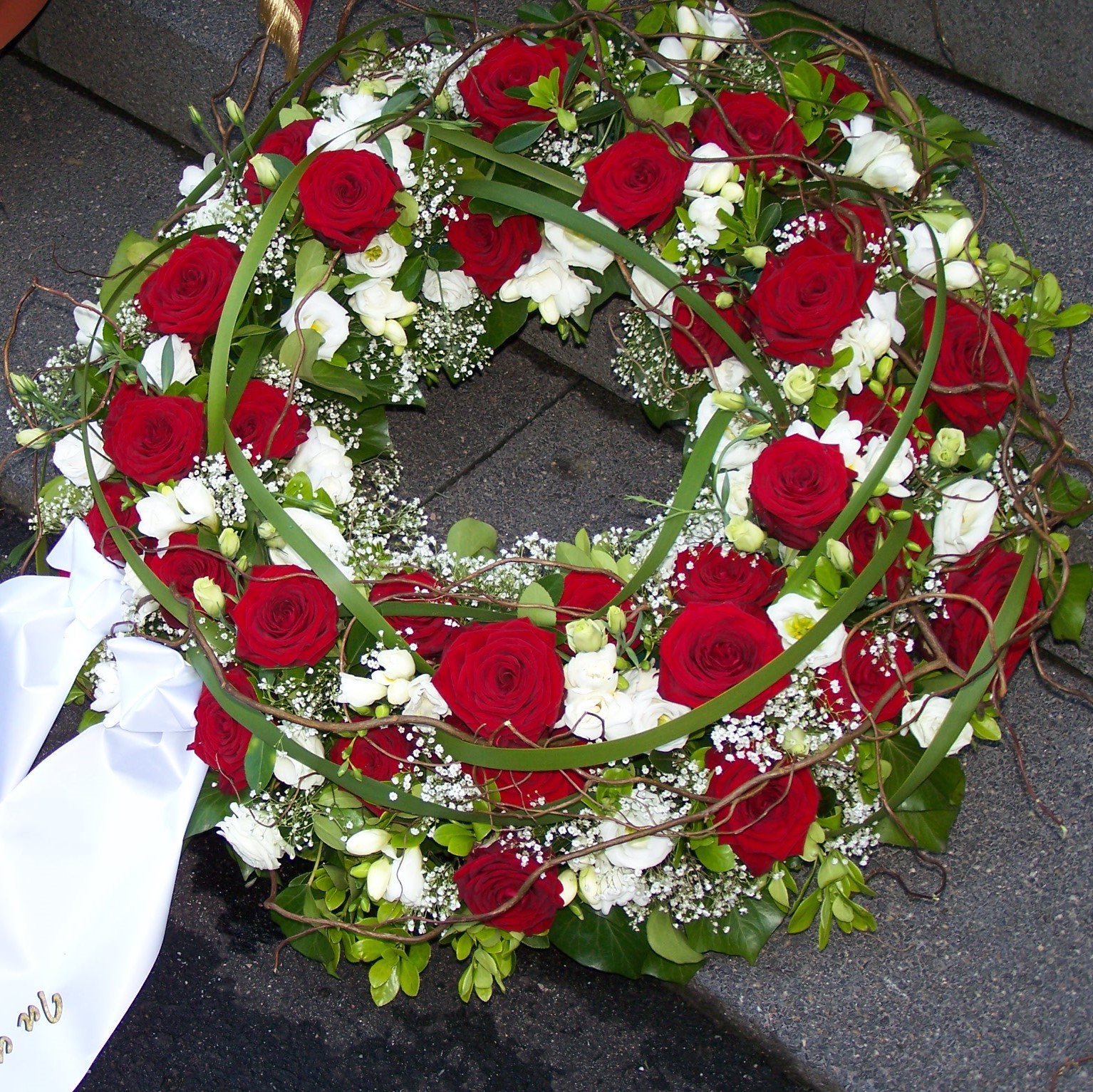 Trauerkranz rundgesteckt mit roten Rosen,weißen Blumen und Grün Bild 1
